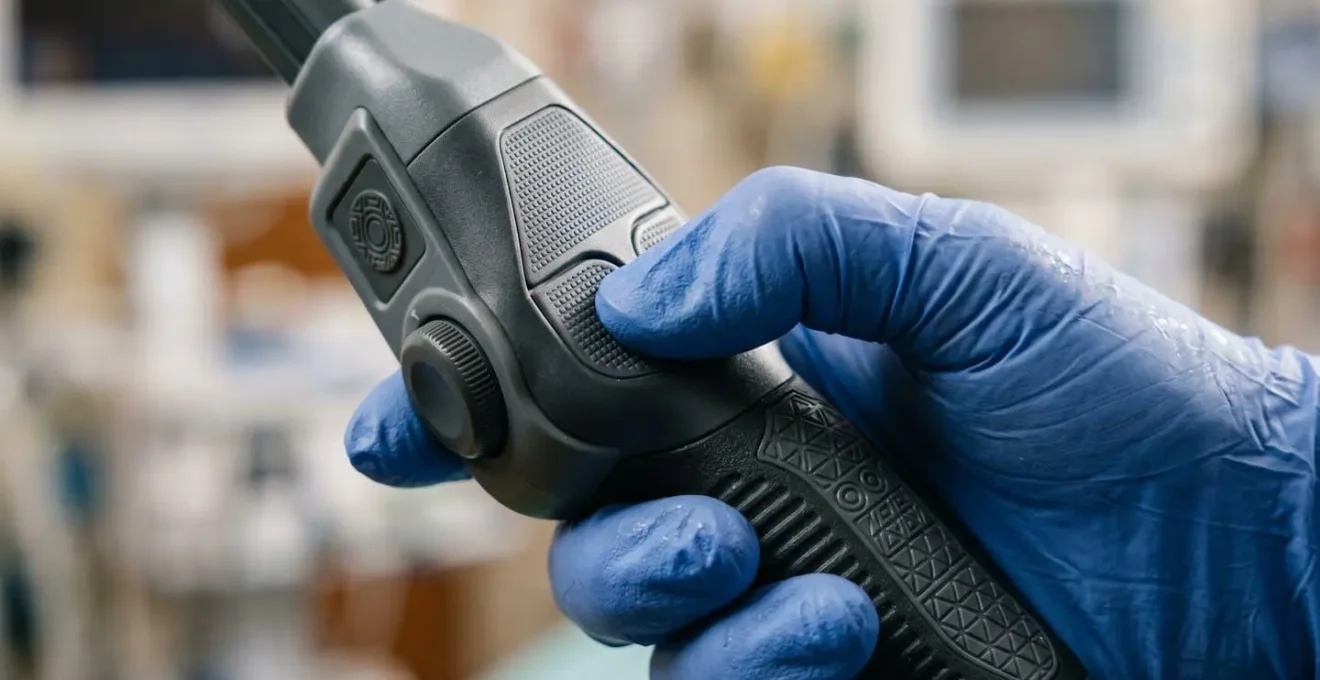 Close-up of nurse hands interacting with medical device prototype during testing