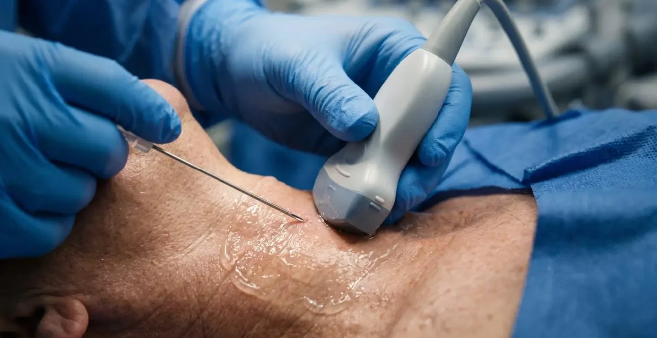 Close-up view of ultrasound probe guiding needle insertion for central venous access
